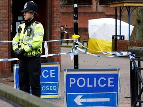 A police officer stands on duty at a cordon near a bench covered in a protective tent at The Maltings shopping centre in Salisbury, southern England, on March 12, 2018.