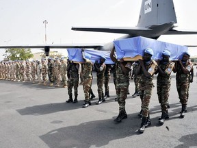 UN peacekeeper soldiers carry the coffinsof two Dutch UN peacekeepers accidently killed during their funerals on July 11, 2016 at the Bamako airport.