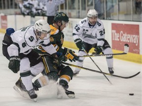 Tyson Baillie of the University of Alberta Golden Bears tries to skate away from Jesse Forsberg of the University of Saskatchewan Huskies at Clare Drake Arena in Edmonton on March 3, 2018.