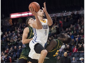 Ryerson Rams' Manny Diressa, centre, drives between Alberta Golden Bears Brody Clarke, left, and Ivan Ikomey during the second half of quarterfinal action in the USports men's basketball national championship in Halifax on Thursday, March 8, 2017.
