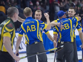 Northern Ontario second E.J. Harnden, left, heads past Alberta lead Karrick Martin, skip Brendan Bottcher, third Darren Moulding and second Brad Thiessen, left to right, as they celebrate their 6-5 victory in Page 3 vs 4 playoff action at the Tim Hortons Brier at the Brandt Centre in Regina on Saturday, March 10, 2018. Alberta advances to the semifinal. THE CANADIAN PRESS/Andrew Vaughan ORG XMIT: XAV108