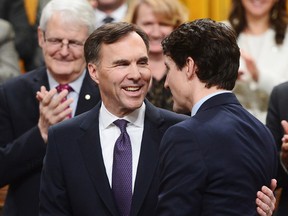 Finance Minister Bill Morneau is congratulated by Prime Minister Justin Trudeau after delivering the federal budget in the House of Commons in Ottawa on Tuesday, Feb. 27, 2018. THE CANADIAN PRESS/Sean Kilpatrick