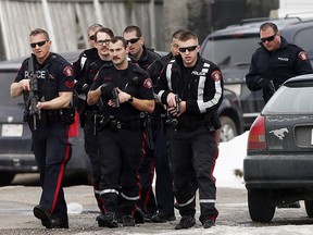 Calgary Police tend to one of their own who was shot at scene in Abbeydale on Tuesday March 27, 2018. Darren Makowichuk/Postmedia