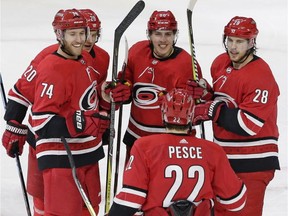 Carolina Hurricanes forward Teuvo Teravainen, centre, s congratulated following his winning goal by Jaccob Slavin (74), Sebastian Aho (20), Brett Pesce (22) and Elias Lindholm (28) during NHL action against the New Jersey Devils in Raleigh, N.C., on March 2, 2018.
