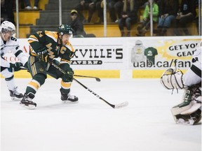 Golden Bears captain Riley Kieser, centre, fends off University of Saskatchewan Huskies  defenceman Jesse Forsberg and goes in on goaltender Taran Kozun in Game 2 of the Canada West championship at Clare Drake Arena on March 3, 2018.