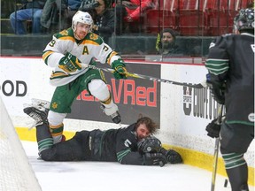 University of Alberta Golden Bears forward Stephane Legault hops over a helmetless University of Saskatchewan Huskies defenceman Jesse Forsberg as Alberta overcame a 2-0 deficit in the third period to win Saturday's U Sports national championships semifinal 3-2 in overtime in Fredericton, N.B. (Photo courtesy of U Sports)