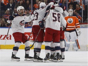 Columbus Blue Jackets players celebrate a goal as Edmonton Oilers goalie Cam Talbot (33) looks on during second period NHL action in Edmonton, Alta., on March 27, 2018.