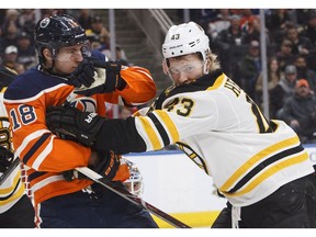 Boston Bruins' Danton Heinen (43) and Edmonton Oilers' Ryan Strome (18) rough it up during first period NHL action in Edmonton on Tuesday February 20, 2018.