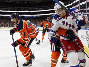 Edmonton Oilers defenceman Oscar Klefbom digs the puck out of the corner against New York Rangers' Jesper Fast in Edmonton on Saturday, March 3, 2018.