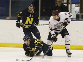 NAIT's Jarid Hauptman (16) is knocked down by MacEwan's Stefan Danielson during the second period of Game 1 of the Alberta Colleges Athletic Conference men's hockey final at NAIT Arena at Northern Alberta Institute of Technology in Edmonton on March 16, 2018.