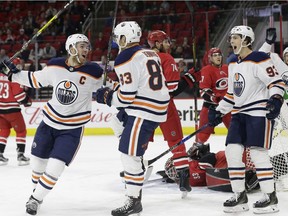 Edmonton Oilers' Matt Benning (83) is congratulated by Connor McDavid, left, and Ryan Nugent-Hopkins (93) following Benning's goal against the Carolina Hurricanes during the first period of an NHL hockey game in Raleigh, N.C., Tuesday, March 20, 2018.