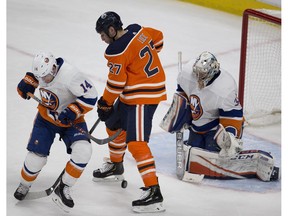 Edmonton Oilers forward Milan Lucic (27) can't get his stick on the puck as it heads towards New York Islanders goalie Christopher Gibson (33) in Edmonton on Thursday, March 8, 2018. (Greg Southam)
