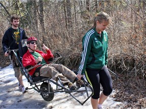 Danny Wein is transported along an Edmonton river valley trail in an Alberta Abilities Lodges Society TrailRider by family friends Cam Mang, left, and Annika Mang.