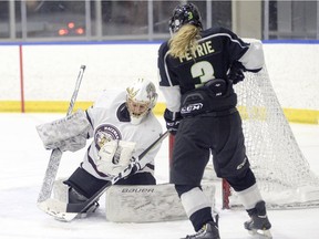 MacEwan University Griffins goaltender Sandy Heim makes a glove save in front of Red Deer College Queens' Jade Petrie on the doorstep, one of 39 saves she made on Thursday night. (Len Joudrey/MacEwan Athletics)