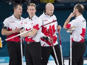Canadians Kevin Koe, centre, with teammates Ben Hebert, left, Marc Kennedy, second left, and Brent Laing, right, look on while playing Switzerland during the men's bronze-medal game at the 2018 Olympic Winter Games in Gangneung, Korea on Friday, February 23, 2018. (THE CANADIAN PRESS/Nathan Denette)