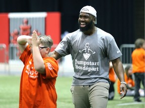 Hamilton Tiger-Cats linebacker Simoni Lawrence celebrates with a student during a Jumpstart event at the RBC Convention Centre that is part of CFL Week in Winnipeg on Thurs., March 22, 2018. Over 150 kids from Greenway and Victory schools were able to participate in drills with current CFL stars. Kevin King/Winnipeg Sun/Postmedia Network