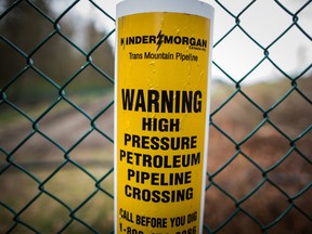 A sign warning of an underground petroleum pipeline is seen on a fence at Kinder Morgan's facility where work is being conducted in preparation for the expansion of the Trans Mountain Pipeline, in Burnaby, B.C., on Monday April 9, 2018.