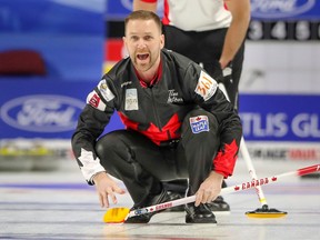 Canada skip Brad Gushue calls to his sweepers as Switzerland second Raphael Maerki looks on at the men's world curling championship in Las Vegas on April 1, 2018