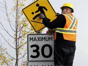 City crews set up signs for a 30 km/h playground zone on Haddow Drive in Edmonton on Friday, Sept. 15, 2017.