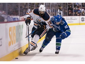 Jujhar Khaira #16 of the Edmonton Oilers and Henrik Sedin #33 of the Vancouver Canucks battle for the puck in NHL action on March, 29, 2018 at Rogers Arena in Vancouver.