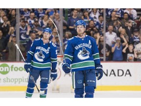 Daniel Sedin #22 and Henrik Sedin #33 of the Vancouver Canucks salute the fans after playing in their final home game of their career against the Arizona Coyotes in NHL action on April, 5, 2018 at Rogers Arena in Vancouver.