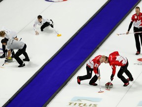 Canadian,right, and Russian curlers compete during the men's world curling championships on April 5, 2018