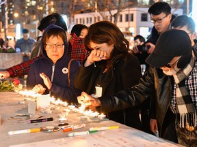 People light candles and mourn the victims of the Toronto van attack.