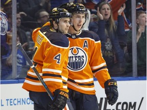 Edmonton Oilers Kris Russell (4) and Ryan Nugent-Hopkins (93) celebrate a goal against the Vancouver Canucks during second period NHL action in Edmonton, Alta., on Saturday April 7, 2018.