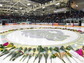 Flowers lie at centre ice as people gather for a vigil at the Elgar Petersen Arena, home of the Humboldt Broncos, to honour the victims of Friday's fatal bus accident on April 8, 2018 in Humboldt, Canada.