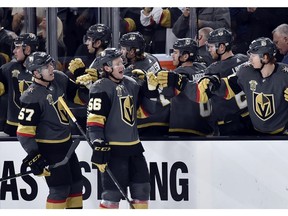 Vegas Golden Knights left wings David Perron (57) and Erik Haula celebrate with players on the bench after Haula scored against the Edmonton Oilers during the third period of an NHL hockey game Thursday, Feb. 15, 2018, in Las Vegas. The Golden Knights won 4-1.