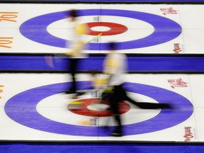 In this photo taken with a slow shutter speed, China delivers a stone against Canada during the men's world curling championships in Las Vegas on April 5, 2018