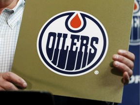 Oilers Entertainment Group CEO Bob Nicholson holds up a NHL draft card as he speaks about the Edmonton Oilers winning the draft lottery and potentially selecting top prospect Connor McDavid during a press conference held at Rexall Place in Edmonton on April 20, 2015.