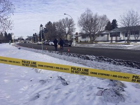 Edmonton police officers pick up evidence markers as homicide detectives probe an early morning shooting at 150 Avenue and 92 Street near the Evansdale Community League in Edmonton, Alta., on Sunday, April 8, 2018.