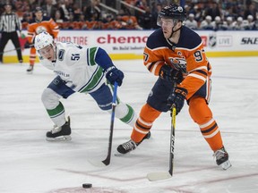 Connor McDavid of the Edmonton Oilers, moves into the offensive zone despite the efforts of Troy Stecher of the Vancouver Canucks at Rogers Place in Edmonton on April 7, 2018.