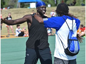 A happy Ajou Ajou, a grade 10 student at Harry Ainlay School about to hug his coach Patrick Powell after breaking the record in high jump while competing during the Edmonton zone Track and Field Finals at Foote Field in Edmonton, May 24, 2018.