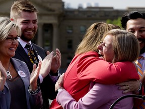 Alberta Premier Rachel Notley (right) hugs Energy Minister Margaret McCuaig-Boyd during a press conference where Notley announced that the Government of Canada, with support from the Government of Alberta, has purchased the Trans Mountain Pipeline and associated assets, during a press conference outside the Alberta Legislature in Edmonton Tuesday May 29, 2018. Photo by David Bloom