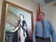 Joe Zasada, 36, poses before a portrait of the Queen in the St. John's Ambulance building at 12304 118 Ave. in Edmonton on Wednesday, May 16, 2018. Zasada is chairman of the Royal Commonwealth Society of Canada and will be waking up early to catch the royal wedding on Saturday, May 19, 2018.