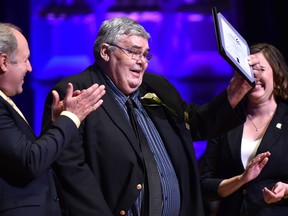 Sports Columnist Terry Jones holds up his award after being inducted into the Sports Hall of Fame during the Salute to Excellence Hall of Fame Induction Ceremony at the Winspear Centre in Edmonton June 11, 2018. Ed Kaiser/Postmedia