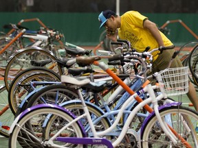 A volunteer looks at the bikes up for sale during The Edmonton Bike Swap at the Kinsmen Sport Centre in Edmonton on Saturday, May 12, 2018. Police say nearly 600 bikes have been reported stolen in the city so far this year.