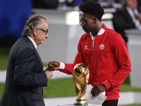 Decio de Maria, President of the Football Association of Mexico, left, and Edmontonian Alphonso Davies of Canada, right, present a joint United bid by Canada, Mexico and the United States to host the 2026 World Cup at the FIFA congress in Moscow, Russia, Wednesday, June 13, 2018.