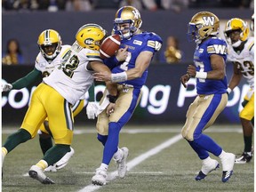 Winnipeg Blue Bombers quarterback Chris Streveler (17) fumbles the ball after getting hit by Edmonton Eskimos' Brandon Pittman (92) during the second half of pre-season CFL action in Winnipeg Friday, June 1, 2018.