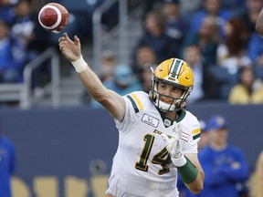 Edmonton Eskimos quarterback Zach Kline (14) throws with pressure from Winnipeg Blue Bombers' Jackson Jeffcoat (94) during the first half of pre-season CFL action in Winnipeg Friday, June 1, 2018.