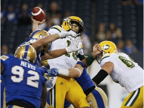 Edmonton Eskimos quarterback Mike Reilly (13) gets sacked by the Winnipeg Blue Bombers during the first half of CFL action in Winnipeg Thursday, June 14, 2018.