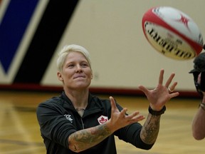 Retired rugby player Jennifer Kish tosses a ball while talking with students at W.P. Wagner High School in Edmonton on June 6, 2018.