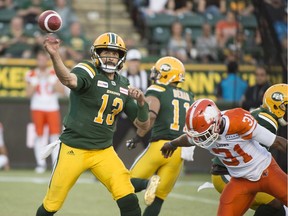 Quarterback Mike Reilly (13) of the Edmonton Eskimos, throws a pass in the first half before Otha Foster III (31)of the B.C. Lions arrives on June 29, 2018 at Commonwealth Stadium in Edmonton.