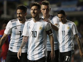 Argentina's Manuel Lanzini, left, Giovanni Lo Celso, second right, and Angel Di Maria, right, congratulate teammate Lionel Messi, second left, after his hat trick during a friendly soccer match between Argentina and Haiti at the Bombonera stadium in Buenos Aires, Argentina on May 29, 2018. Natacha Piisarenko / AP