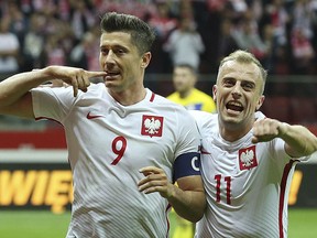Poland's Robert Lewandowski, left, celebrates scoring their third goal from the penalty spot with Kamil Grosicki during the World Cup Group E qualifying soccer match between Poland and Kazakhstan at National stadium in Warsaw on Sept. 4, 2017