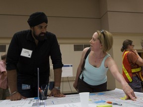 City of Edmonton employee Charan Lotey listens to Kelly Buziak's concerns at an open house for neighbourhood reconstruction in Old Strathcona on June 20, 2018.