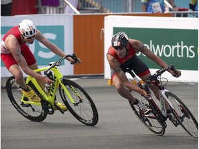 Iestyn Harrett of Wales, left, and Tyler Mislawchuk of Canada compete during the mixed team relay triathlon at the Southport Broadwater Parklands during the 2018 Commonwealth Games on the Gold Coast, Australia, Saturday, April 7, 2018.