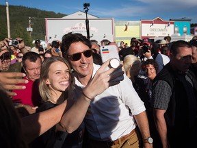 Prime Minister Justin Trudeau poses for a selfie with a woman. Sunday, July 1, 2018. THE CANADIAN PRESS/Darryl Dyck